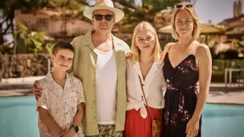 White Norwegian family of four with son, daughter, husband and wife in warm-weather clothes in front of a pool