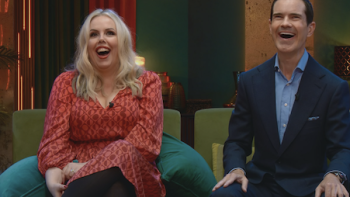 LOL: Last One Laughing UK TV show screenshot 1: Roisin Conaty and Jimmy Carr sitting on sofa laughing.