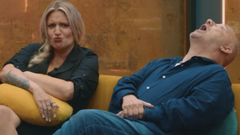 LOL: Last One Laughing UK TV show screenshot 2: Man and woman sitting on a couch, woman pouting, man laughing.