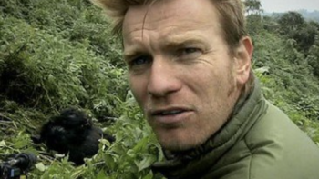 Long Way Down TV show screenshot 2: Ewan McGregor faces camera and gorillas are visible behind his right shoulder.  