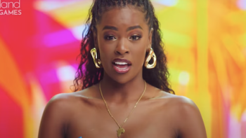 Love Island Games TV show screenshot 3: Headshot of female castmember talking with pink and yellow palm leaves in background.