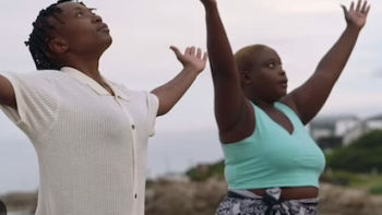 v screenshot 2: A lgbtq+ couple does yoga on the beach. 