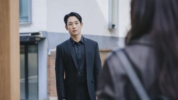 Love Next Door TV show screenshot 3: Jung Hae-in wears an all-black suit while standing in the middle of the street.