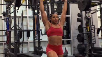 Love & WWE TV show screenshot 1: Bianca Belair in red sports bra deadlifts weight. 