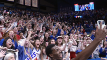 Made for March TV show screenshot 3: A Jayhawks player takes a selfie with people celebrating in the bleachers.