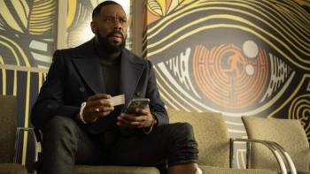 The Madness TV show screenshot 1: Muncie Daniels (Domingo) sits in front of a mural depicting a large, red eyeball