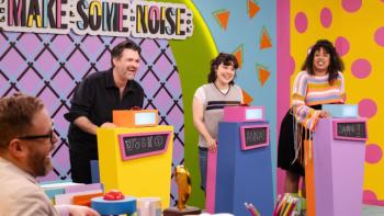 Make Some Noise: Josh Ruben, Anna Garcia, and Jiavani Linayao stand behind colorful contestant podiums on the Make Some Noise set