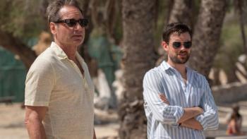 Malice TV show screenshot 3: Jamie and Adam stand together on a beach, looking at something off-camera