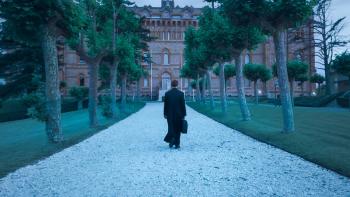 Marcial Maciel: The Wolf of God TV show screenshot: A priest walks toward a building on a wide path