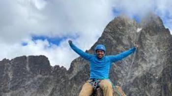 Memphis to the Mountain TV show screenshot #2: a climber sits atop a mountain with arms raised