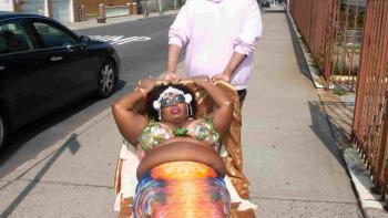 MerPeople TV show screenshot 1: Mermaid Ché Monique being carried on the street.