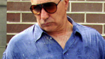 Mob War: Philadelphia vs. the Mafia TV show screenshot 3: John Scarfa wearing sunglasses in blue shirt.