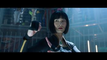 MPower TV show screenshot: A Chinese woman stands in a dark fighting ring with one of her fists out in front of her. 