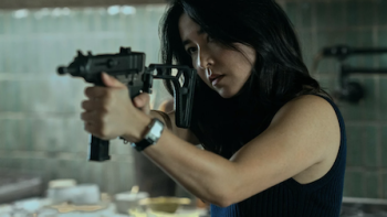Mr. & Mrs. Smith TV show screenshot 2: Jane aiming semi-automatic weapon.