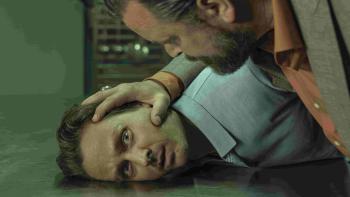 Murder Mindfully TV show screenshot 3: Schilling has his face pressed against a steel table. Sascha Alexander Gersak holds Schilling’s head down.