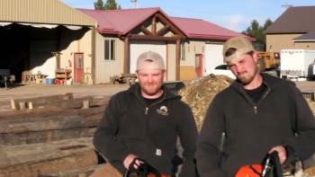 Lincoln Log Masters TV show screenshot: two white men stand in front of a large building. 