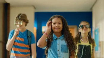 Mystery League TV: Mike, Millie and Marta confidently walk the school hallway. Millie at center with a pen in her hair. Marta with special glasses.