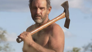 Naked and Afraid: Solo: Survivalist James Lewis is bare chested and holds an axe. 