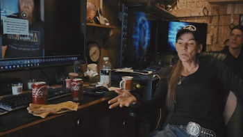 Neighbors TV show screenshot 1: A woman with baseball cap looks at neighbor's TikTok video on a screen. 