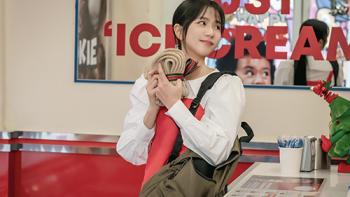 Newtopia TV show screenshot 1: Young-joo stands in an ice cream shop, smiling and holding a knitted gift with a ribbon around it