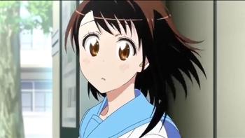 Nisekoi TV show: A girl with brown hair and brown eyes stands outside behind a park building, she is slightly blushing and looks like she is daydreaming.