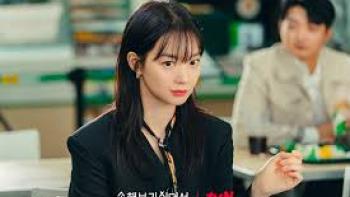 No Gain No Love TV show screenshot #1: A young woman sits in the foreground; a young man sits a few feet behind her.