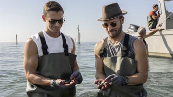 No Taste Like Home with Antoni Porowski TV show screenshot 1: Porowski and Justin Theroux wear hip waders as they stand in the ocean examining mussels