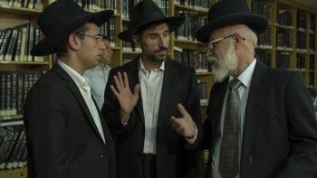 Our Boys Television: Scene 2 Orthodox Jewish men in black suits and hats talk about the kidnapping in a book-lined library. 