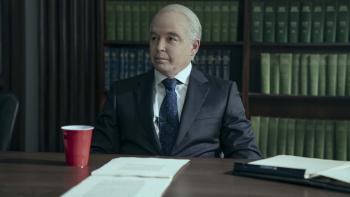 Painkiller TV Show Screenshot 3: Matthew Broderick as Richard Sackler sits in an interview at a table. A stack of paper and a red cup sits in front of