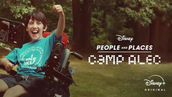 Image from the Camp Alex episode of People & Places shows a young boy in a motorized wheelchair pumping his fist and smiling widely