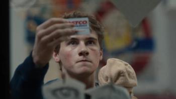Phony TV show screenshot 2: Sonny holds up a Costco card, trying to compare its picture with his mother's face in real life