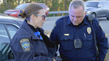 Police 24/7 TV show screenshot 2: A female and male police officer in uniform talk. 
