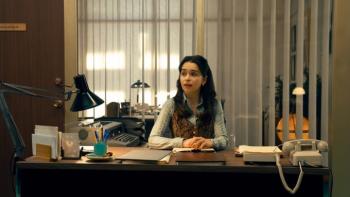 Ponies TV show screenshot 2: Bea sits at a desk with 1970s office equipment with her arms folded