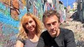 Positive Energy TV show: male and female hosts sit outdoors in front of graffiti-painted wall