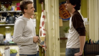 Roommates TV: James and Mark smile at each other indoors by the kitchen