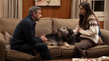 Rooster TV show screenshot 2: Greg and Katie sit talking together on a sofa in a living room; between them is a fluffy dog 