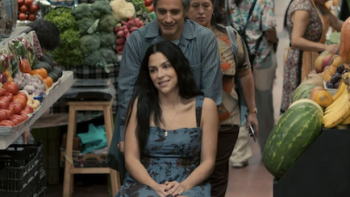 Santita TV show screenshot 2: Alejandro pushes Santita in her wheelchair through a food market.