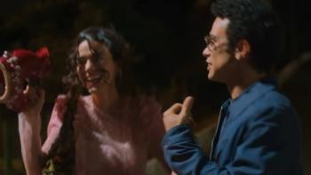 Benefits with Friends TV show screenshot: A brunette woman and a dark-haired man with glassed laugh together