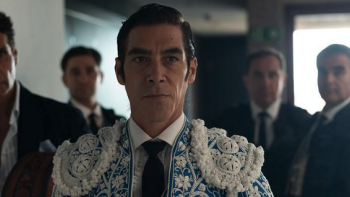 Fate (La Suerte) TV show screenshot: A dark-haired White man in a matador outfit stand in front of four men blurred in the background