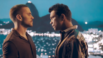 Rulers of Fortune TV show screenshot: Two dark-haired men stare at each other in front of a mountain-top background lit up with many lights beneath
