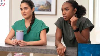 Scrubs TV show screenshot 3: Amara and Dashana lean on a nurse's station at Sacred Heart and look seriously at something off-camera
