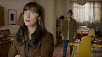 La Liberación TV show screenshot: A dark-haired woman looks upward while another woman who looks like her standing behind her in the background