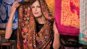 Joanna Lumley's Silk Road Adventure: Joanna Lumley holds a silk scarf over her head, with colorful scarves hung in the background.