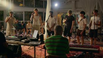 Simon Cowell The Next Act TV show screenshot: A group of young men stand behind microphones singing in a studio