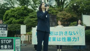 Sins of Kujo TV Show: Kameoka Reiko yells through a megaphone during a protest, with people holding signs behind her