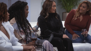 Sistas screenshot 3: Women sit on white sofa drinking wine. 