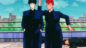 Slam Dunk TV show screenshot 3: Hanamichi compares his height to Rukawa's. They're on the school rooftop, two teens on the ground behind them.