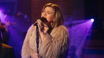 Songs and Stories with Kelly Clarkson TV show screenshot #1: Clarkson sings while wearing a tan, furry jacket