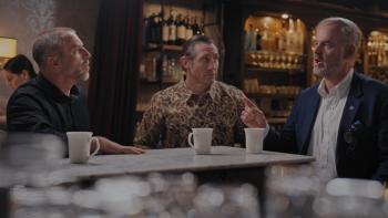 From Left to Right: Jeff Tiegs, Tim Kennedy, and David Johnson sit in a bar. There are white coffee mugs on a counter in front of them.