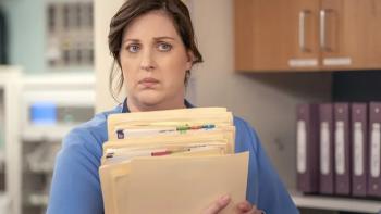 St. Denis Medical TV show screenshot 3: Alex holds a number of manila file folders and looks as if she's heard something she's not sure she likes